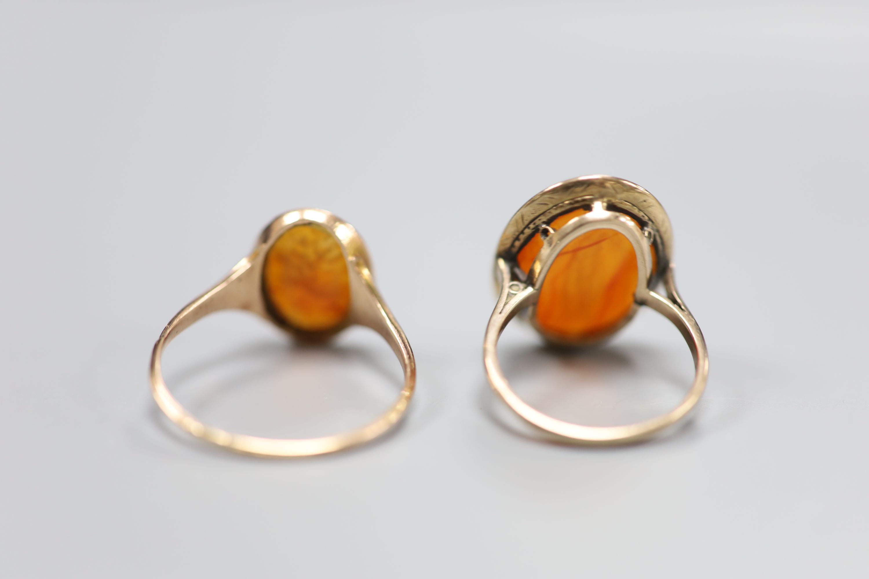 Two 19th century yellow metal and oval carnelian intaglio rings, carved with a bust or figure, one stamped 9ct,